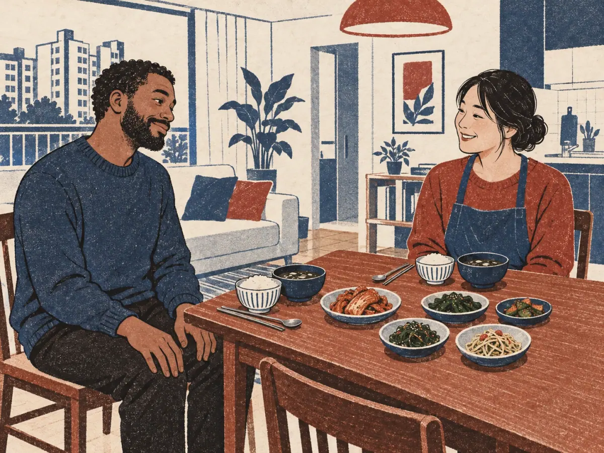 An adult guest nods appreciatively to the host before eating a Korean meal of rice, soup and side dishes.